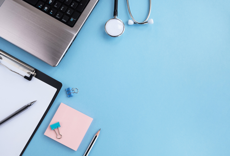 A laptop, stethascope and clipboard used in our healthcare fieldwork services