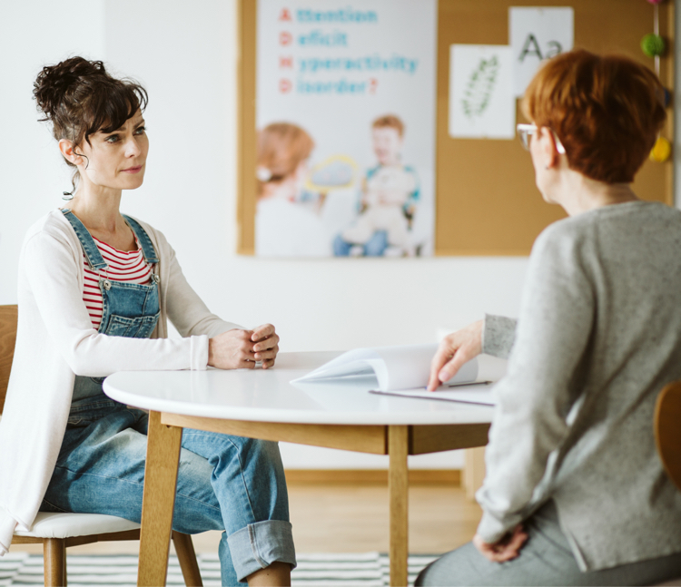 Two women at a table conducting an In Depth Interview (IDI)