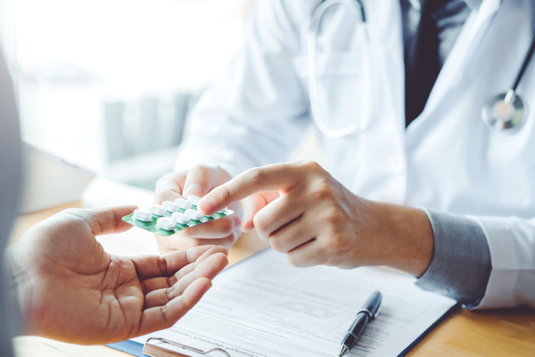 A doctor handing a patient some medicine - we recruit healthcare professionals