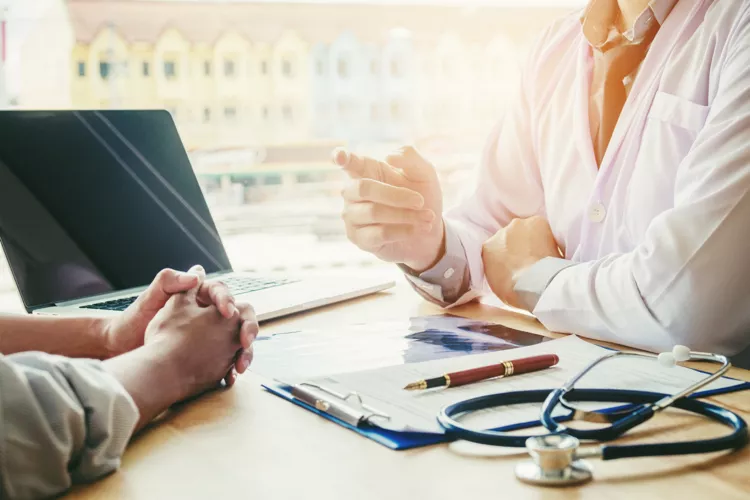 Doctor and person at a desk to represent "iThink Tech Sheet"