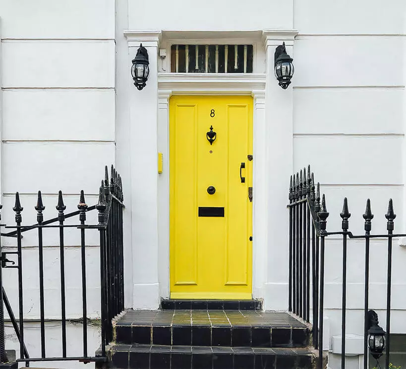 A picture of a yellow front door with the number 8 on it